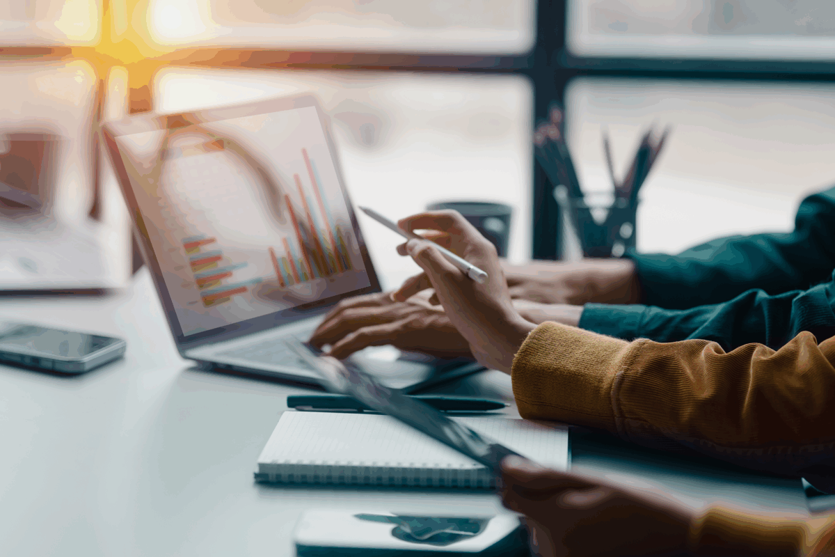 Zwei Menschen besprechen gemeinsam etwas an einem Laptop. Eine Person zeigt auf den Bildschirm während die andere Person auf der Tastatur tippt.